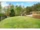 A spacious backyard with a patio, outdoor fireplace, covered outdoor kitchen, and a deck with lawn at 361 Nance Rd, Stanfield, NC 28163