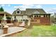 A backyard view featuring a deck, patio, and outdoor kitchen, all connected by stone steps and a landscaped garden at 361 Nance Rd, Stanfield, NC 28163