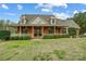 Lovely brick home with a covered porch, featuring manicured landscaping and a well-maintained lawn at 361 Nance Rd, Stanfield, NC 28163
