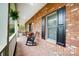 Inviting brick front porch with rocking chairs, black shutters, and manicured hedges at 361 Nance Rd, Stanfield, NC 28163