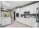 Well-lit kitchen with white cabinetry, gray backsplash, and modern appliances at 361 Nance Rd, Stanfield, NC 28163