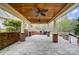 Covered outdoor kitchen featuring wood ceiling, ceiling fans, stone counters, brick accents, and paver flooring at 361 Nance Rd, Stanfield, NC 28163