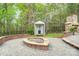 Features a fire pit, brick patio, outdoor stone fireplace, and a dog kennel nestled in a lush, wooded backyard at 361 Nance Rd, Stanfield, NC 28163