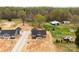 Expansive aerial view of a new home build, showcasing the surrounding wooded acreage and outbuildings at 3957 Miller Rd, Salisbury, NC 28147