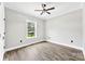 Bedroom boasts a ceiling fan, wood flooring, and a window with a view of a barn at 3957 Miller Rd, Salisbury, NC 28147