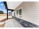 View of the front of a new house from the front porch showcasing neutral vinyl siding and stone accents at 3957 Miller Rd, Salisbury, NC 28147