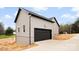 View of the new construction showing the garage with black door and modern siding and manicured landscape at 3957 Miller Rd, Salisbury, NC 28147