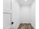 Hallway featuring wood floors, white walls, trim, and a solid white door at 3957 Miller Rd, Salisbury, NC 28147