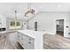 An open-concept living space features a modern kitchen island, fireplace, and hardwood floors for seamless living at 3957 Miller Rd, Salisbury, NC 28147