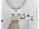Laundry room featuring a sink, white cabinets, and wood floors at 3957 Miller Rd, Salisbury, NC 28147