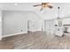 Bright living room with vaulted ceiling, modern fan, hardwood floors, and access to kitchen and outdoor patio at 3957 Miller Rd, Salisbury, NC 28147