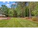 An expansive green lawn with mature trees creating a serene, private oasis at 4159 Isle Of Pines Dr, Denver, NC 28037