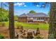 Inviting backyard with a fire pit and outdoor seating, framed by mature trees and lush lawn at 4159 Isle Of Pines Dr, Denver, NC 28037