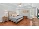 This bedroom features a tray ceiling, wood floors, and natural light at 4159 Isle Of Pines Dr, Denver, NC 28037