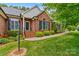 Charming brick facade featuring manicured landscaping, black shutters, and a welcoming entrance at 4159 Isle Of Pines Dr, Denver, NC 28037