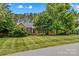 Charming brick home featuring a lush, manicured front lawn and mature trees offering great curb appeal at 4159 Isle Of Pines Dr, Denver, NC 28037