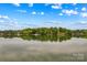 Serene lake view mirroring the sky and tree-lined shores, creating a tranquil and scenic panorama at 4159 Isle Of Pines Dr, Denver, NC 28037