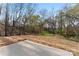 Spacious backyard area with straw covering and mature trees, perfect for outdoor activities and relaxation at 4219 Brownwood Nw Ln, Concord, NC 28027