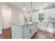 Bright, open kitchen featuring granite countertops, an island with dark hardware, and light colored cabinets at 4219 Brownwood Nw Ln, Concord, NC 28027