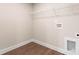 Clean laundry room with wood-look flooring, utility sink hookups, and wire shelving at 4219 Brownwood Nw Ln, Concord, NC 28027