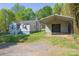 Home featuring fresh exterior paint, mature landscaping, and a detached carport in the rear at 4445 Pioneer Dr, Hickory, NC 28601