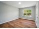 Wood-look floors and neutral walls highlight bedroom with natural light from window at 4607 Crewe Hall Ln, Waxhaw, NC 28173
