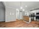 Open-concept dining area featuring a modern light fixture and seamless access to the kitchen with stainless appliances at 4607 Crewe Hall Ln, Waxhaw, NC 28173