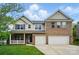 Charming two-story home with brick and siding, a welcoming porch, two-car garage, and well-manicured lawn at 4607 Crewe Hall Ln, Waxhaw, NC 28173