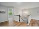 Hallway featuring stairs with dark wood railings and views of an adjacent room with a window at 4607 Crewe Hall Ln, Waxhaw, NC 28173