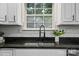 Close-up of the kitchen sink features granite countertops, subway tile backsplash, and a view from the window at 4607 Crewe Hall Ln, Waxhaw, NC 28173