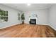 Cozy living room with hardwood floors, a fireplace, and large windows, perfect for relaxing and entertaining at 4607 Crewe Hall Ln, Waxhaw, NC 28173