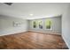 Spacious living room featuring three windows and light-colored walls with modern wood-look floors at 4607 Crewe Hall Ln, Waxhaw, NC 28173