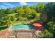 Aerial view of landscaped backyard featuring in-ground pool, red brick patio and pergola at 4607 Crewe Hall Ln, Waxhaw, NC 28173