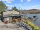 Beautiful lake house with a private dock and lush greenery, offering serene waterfront living and outdoor enjoyment at 466 Shoreline Rd, New London, NC 28127