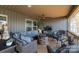 Cozy screened porch with a fire pit, comfortable seating, and a TV, ideal for relaxing and entertaining outdoors at 466 Shoreline Rd, New London, NC 28127