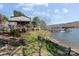 Beautiful lakefront property with lush greenery, a cozy seating area, and a private boat dock at 466 Shoreline Rd, New London, NC 28127