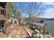 Picturesque backyard featuring a well-maintained lawn, storage sheds, mature trees, and access to the lake and dock at 466 Shoreline Rd, New London, NC 28127