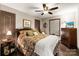 Cozy bedroom featuring wood floors, a ceiling fan, and an inviting floral bedspread at 466 Shoreline Rd, New London, NC 28127