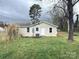 Backyard view of the home featuring a well-maintained lawn and mature trees at 512 Hall St, Salisbury, NC 28144