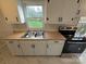 Close up of Kitchen sink with wood countertops, stainless steel appliances, and white cabinets at 512 Hall St, Salisbury, NC 28144