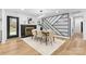 Well-lit dining room featuring modern lighting, an accent wall, and hardwood floors at 7009 Wrentree Dr, Charlotte, NC 28210