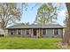 Well-maintained single-story home with shutters, a green lawn, and mature trees providing a picturesque setting at 7009 Wrentree Dr, Charlotte, NC 28210