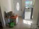 Hallway with a white front door, small window, tile flooring, chest freezer and cleaning supplies at 7122 Pyramid Rd, Hickory, NC 28602