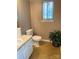 Neutral bathroom features a toilet, sink, window, and plant, offering essential amenities in a simple space at 7307 Meadowland Dr, Charlotte, NC 28215