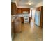 Functional kitchen with oak cabinets, white appliances, and neutral tile flooring at 7307 Meadowland Dr, Charlotte, NC 28215