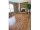 Inviting living room features a classic brick fireplace and gleaming hardwood floors at 7307 Meadowland Dr, Charlotte, NC 28215