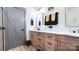 Stylish bathroom featuring dual sinks, bright countertop, wood-look cabinets, and modern fixtures at 782 Chalice Sw St, Concord, NC 28027