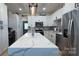 Modern kitchen features white cabinets, stainless steel appliances, granite countertops, and stylish light fixtures at 782 Chalice Sw St, Concord, NC 28027