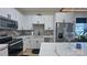 Modern kitchen features stainless steel appliances, white cabinets, granite countertops, and stylish light fixtures at 782 Chalice Sw St, Concord, NC 28027
