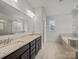Bright bathroom featuring double vanity, large mirror, tile flooring, and separate shower at 9582 Creighton Nw Rd, Concord, NC 28027